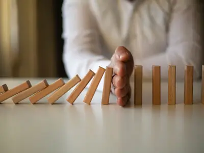 Homem interrompendo queda de dominós